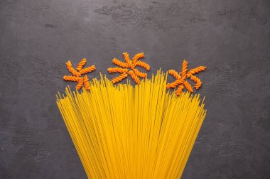 Orange and yellow macaroni spaghetti background concept like a flowers on dark background. italian pasta cooking illustration