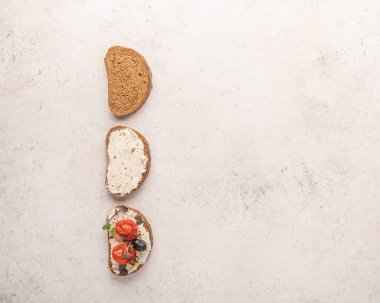 Ekmek, ricotta peyniri, tuzlu somon, fırında domates ve açık arkaplanda yeşillik yapma aşamaları