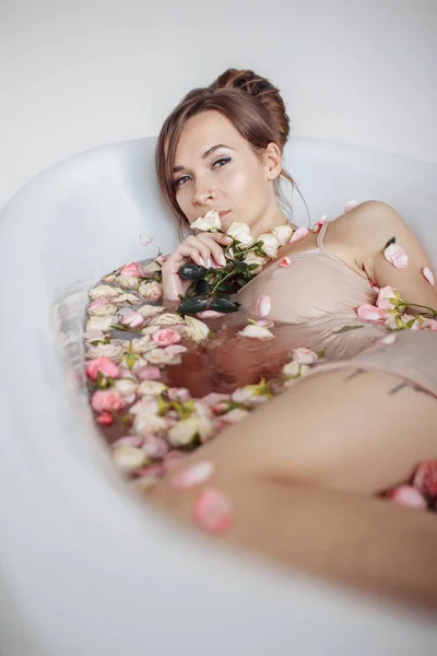 Femme relaxante dans un bain extérieur rond avec des fleurs tropicales, soins de la peau bio, hôtel spa de luxe, photo de style de vie. — Photo