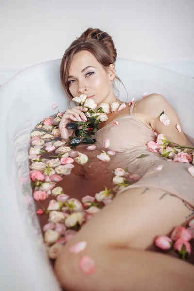 Femme relaxante dans un bain extérieur rond avec des fleurs tropicales, soins de la peau bio, hôtel spa de luxe, photo de style de vie. — Photo