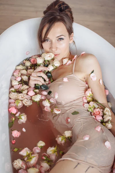 Femme relaxante dans un bain extérieur rond avec des fleurs tropicales, soins de la peau bio, hôtel spa de luxe, photo de style de vie. — Photo