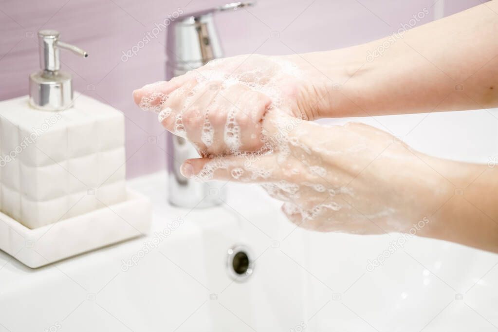 Washing of hands with soap under the crane with water