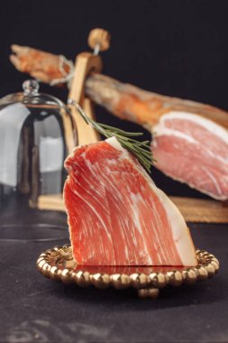 Bir bardak et ve biberiye. Geleneksel İspanyol jamonu arka plandaki cam kubbenin altında serrano, italyan parması, hamon iberico, prosciutto, leg hamon. Durgun yaşam yemeği