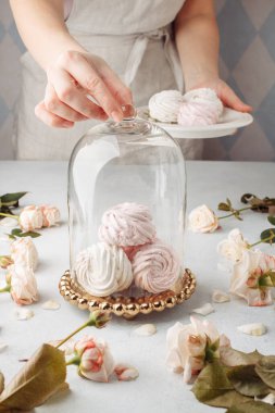 Kırpılmış elleri kapatın ev hanımı aşçı kadın aşçı ya da apron beyazı tişörtlü fırıncı masada kek paketleme zephyr. Metin yiyecek konsepti için yer aç