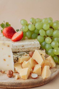 İki büyük parça tuzlanmış domuz yağı ve eski ahşap arka planda fındıklı, çilekli ve üzümlü lezzetli peynir. Kırsal tarzda. Pastırmalı lezzetli bir atıştırma.