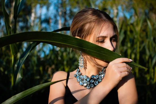 Detailní Záběr Mladé Ženy Černých Šatech Náhrdelníku Náušnic Mezi Zelenými — Stock fotografie