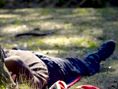 İşçi bahçede bir mola veriyor. Çimenlerde yatarken. tatil konsepti. Başının üstünde şapka