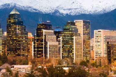 Las Condes ve Providencia bölgelerindeki modern ofis binalarının silueti arkasında And Dağları sıraları olan Santiago de Chile, Güney Amerika