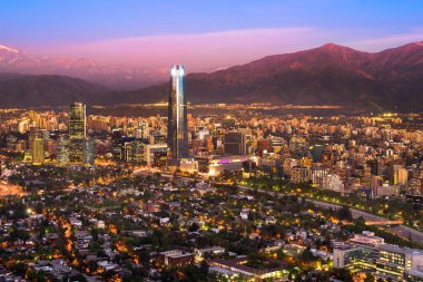 Santiago de Chile 'in alacakaranlıkta panoramik manzarası ve And Dağları sırasının arkasında