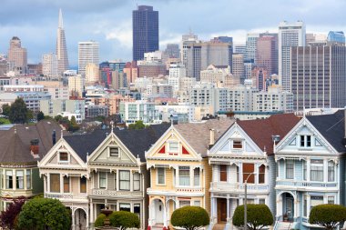 San Francisco, California, United States - Traditional Victorian Houses known as Painted Ladies in Alamo Square and city skyline. clipart