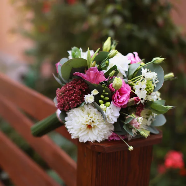 Boeket op houten achtergrond, rode en witte bruiloft. — Stockfoto