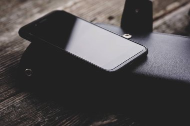 Ahşap arka plan üzerinde siyah smartphone.
