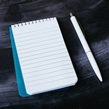 defter ve kalem siyah arka plan üzerine.