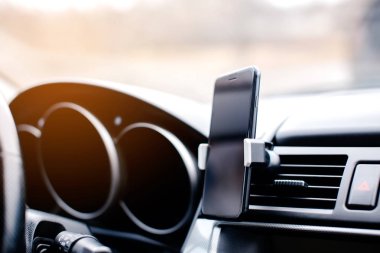 Smartphone in car vent holder.