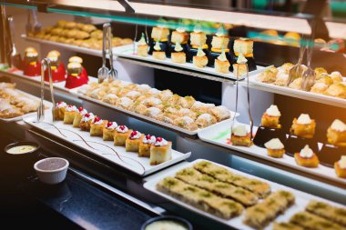 Delicious reception candy bar dessert table. Pieces of sweets cake dessert on a plate.