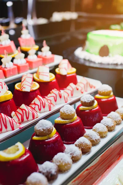 Delicious reception candy bar dessert table. Pieces of sweets cake dessert on a plate.