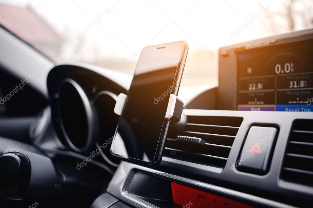 Smartphone in car vent holder.