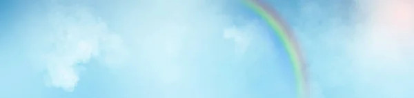 Clouds and rainbows on the blue sky panoramic abstract background.