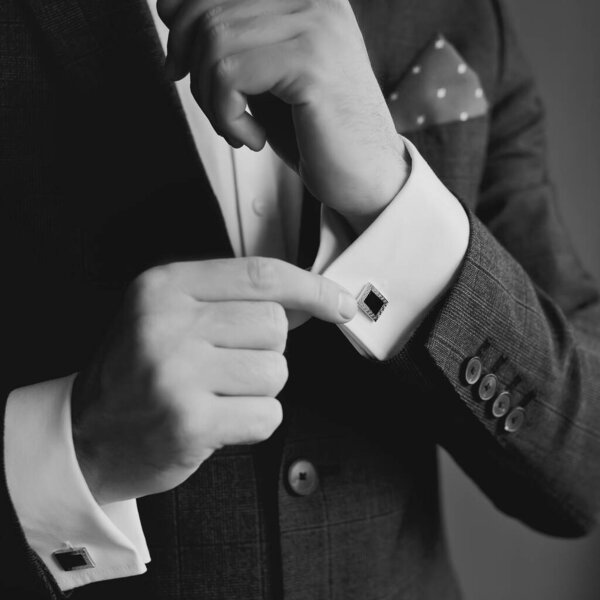 Hands of wedding groom getting ready in suit