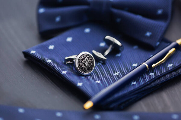 Cufflink, pocket square and pen.