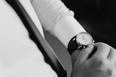 İş adamı kol saatini kontrol ediyor.
