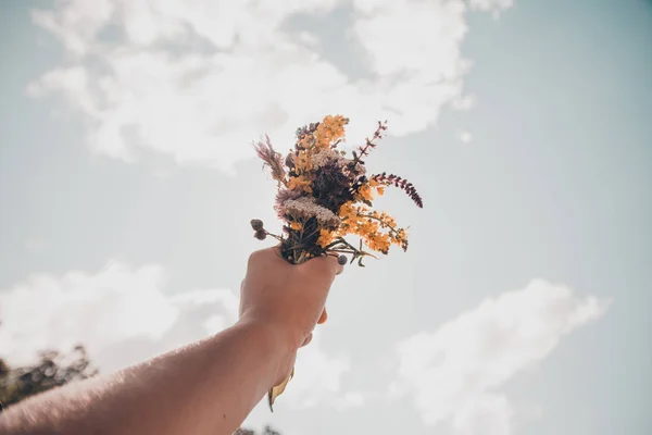 Mains tenant un bouquet de fleurs — Photo