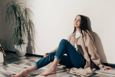 Üzgün kız yerde oturuyor.