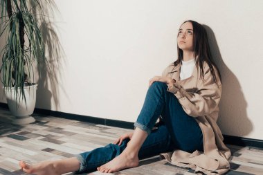 Üzgün kız yerde oturuyor.