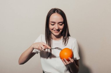 İştahlı bir kız çataldaki portakala bakıyor.. 