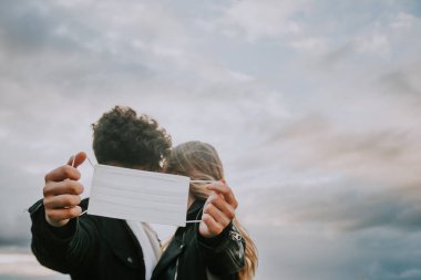 Genç bir çift öpücüklerini saklar. 