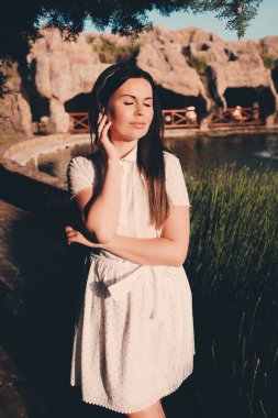 Uzun elbise ve şık şapka genç güzel kadın iyi hava ülke evinde sahiptir. 