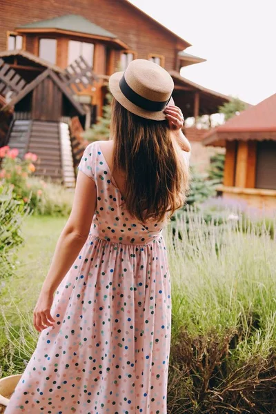 드레스와 모자에 여자는 그녀의 별장에 날씨를 즐긴다 스톡 사진