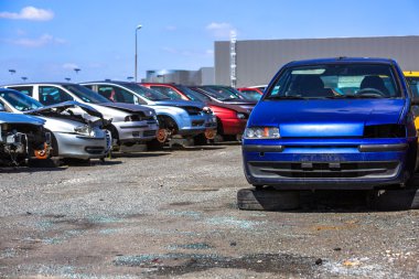 several cars in a scrap yard available for spare parts clipart