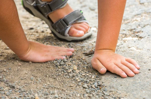 Niño jugando con piedras en el suelo —  Fotos de Stock