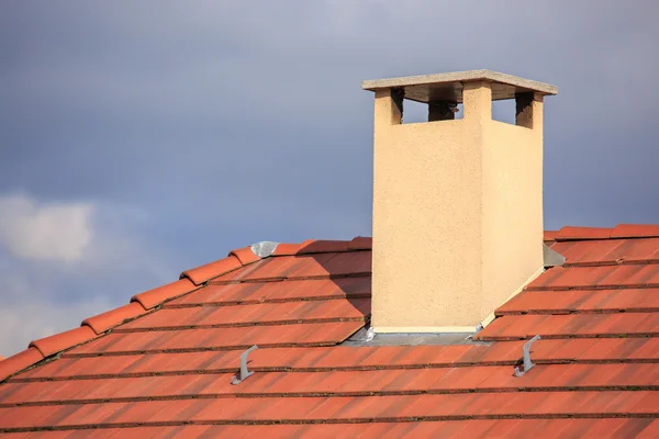 The chimney on top of a red roof — Stock Photo, Image