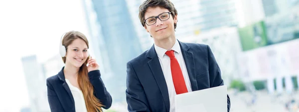 Jóvenes de negocios con operador en segundo plano — Foto de Stock