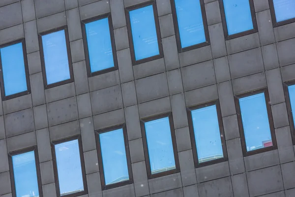 Un grand bâtiment gris foncé avec des fenêtres en verre réfléchissant — Photo