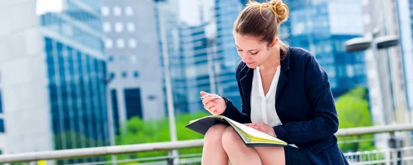 Dynamic young executive taking notes on her agenda — Stock Photo, Image