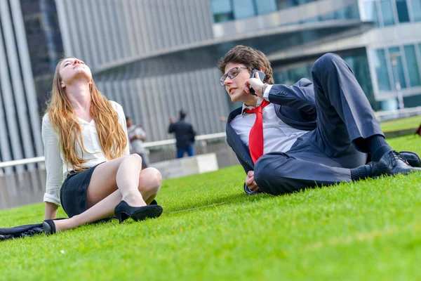 Business team zittend op het gras tijdens een pauze — Stockfoto
