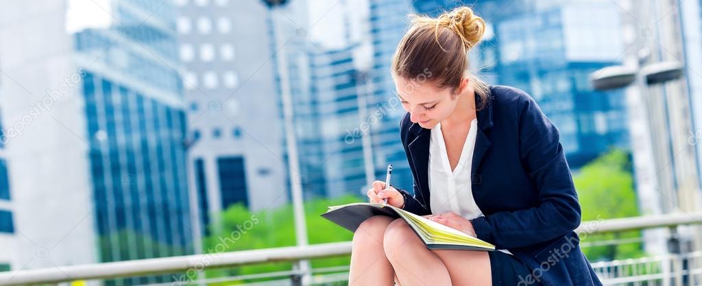 dynamic young executive taking notes on her agenda