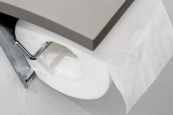 Бумажный рулон туалета на стене современной белой ванной комнаты — стоковое фото