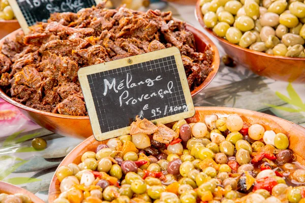 Mezcla provenzal de aceitunas ("Melange provenzal" en francés) en cuenco de madera en el mercado de alimentos en París — Foto de Stock