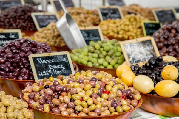 Провансальная смесь оливок ("Melange Provencal" по-французски) в деревянной миске на продовольственном рынке в Париже — стоковое фото