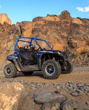 Merzouga, Fas - 21 Şubat 2016: Mavi Polaris Rzr 800 ve Fas'ta bir dağ yolda geçerken pilotlar Merzouga çöl. Merzouga Sahra Güneydoğu Fas'ta bulunan küçük bir köy olduğunu.