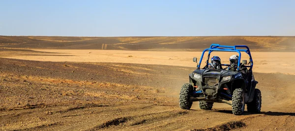 Merzouga, Marrocos - 25 de fevereiro de 2016: Vista panorâmica de Blue Polaris RZR 800 e pilotos no deserto de Marrocos perto de Merzouga. Merzouga é uma pequena aldeia localizada no sudeste de Marrocos. Merzouga. — Fotografia de Stock