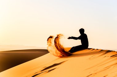 Sahara kumla oynayan genç adam