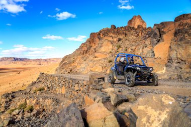 Merzouga, Fas - 21 Şubat 2016: mavi Polaris Rzr 800 Merzouga yakınındaki Fas çölünde bir dağ yolundan geçerken. Merzouga onun dunes, Fas en yüksek ünlüdür.