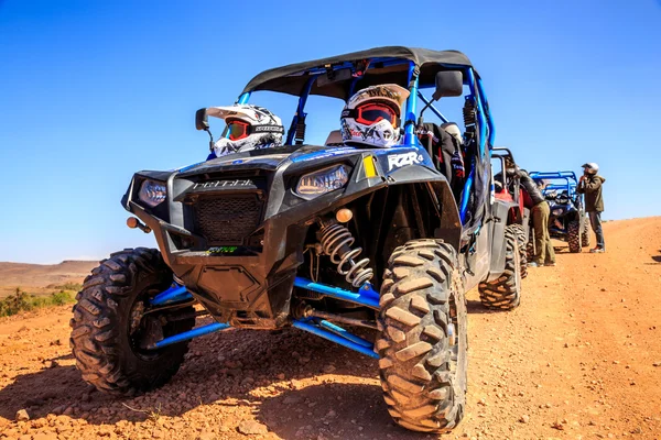 Merzouga, Marrocos - 21 de fevereiro de 2016: Polaris RZR 800 azul alinhado e estacionado sem piloto no deserto de Marrocos perto de Merzouga. Merzouga é famosa por suas dunas, a mais alta de Marrocos . — Fotografia de Stock