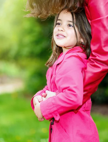 Hübsches kleines Mädchen in den Armen ihrer Mutter — Stockfoto