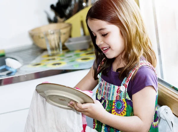 Muito bonito criança menina limpando os pratos — Fotografia de Stock